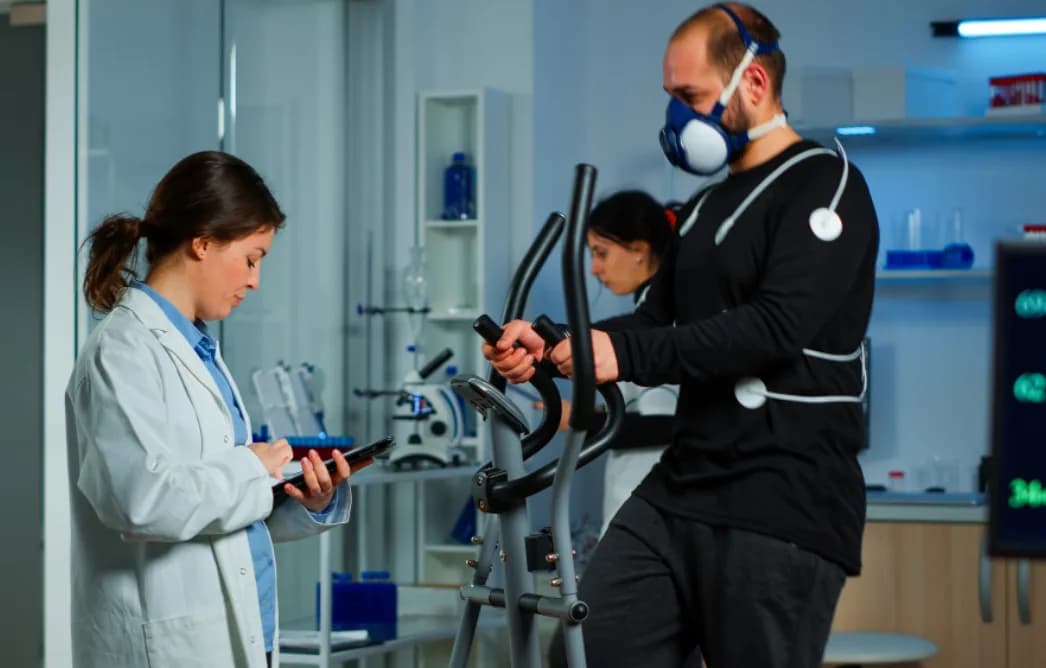 A clinician monitoring an athlete during a cardiopulmonary exercise test